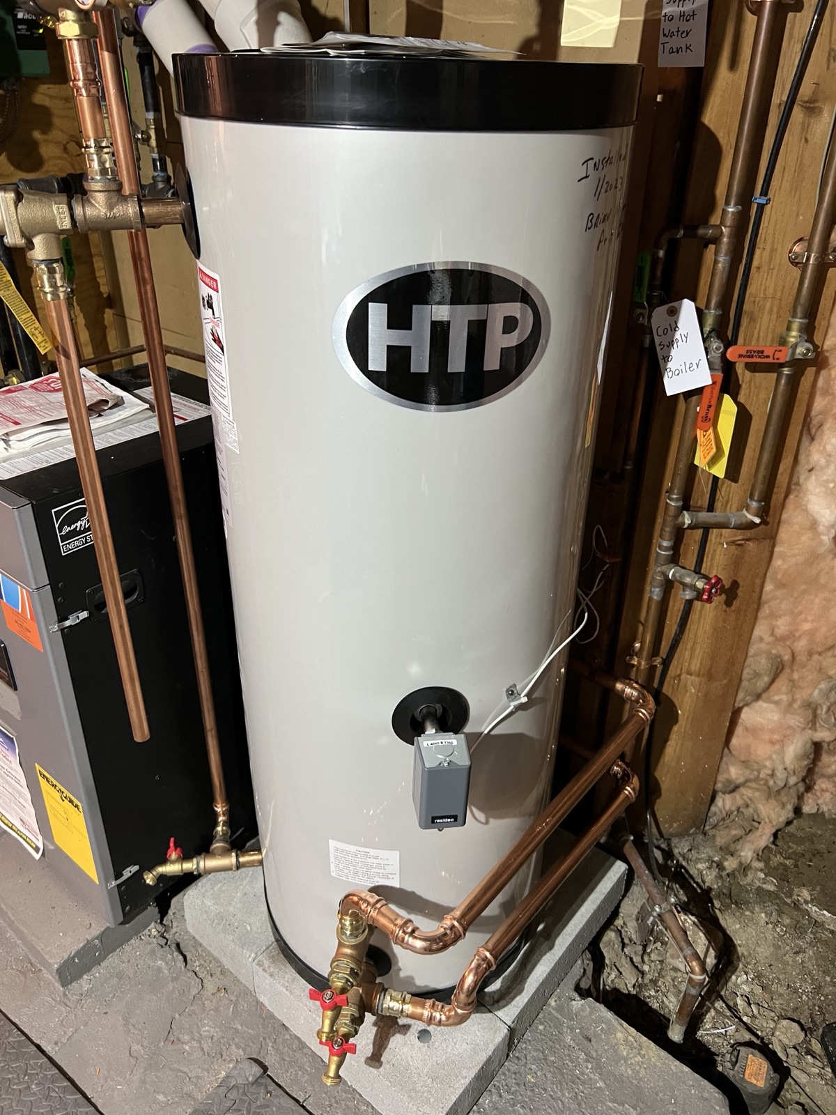 An HTP indirect-fired storage tank piped in copper next to a boiler